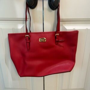 New, never used Michael Kors red bag with gold plating.